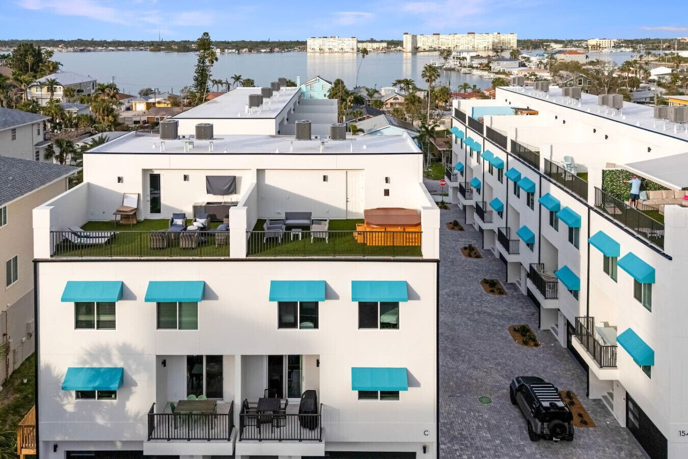 A modern hotel with rooftop terraces, balconies, and a marina view.