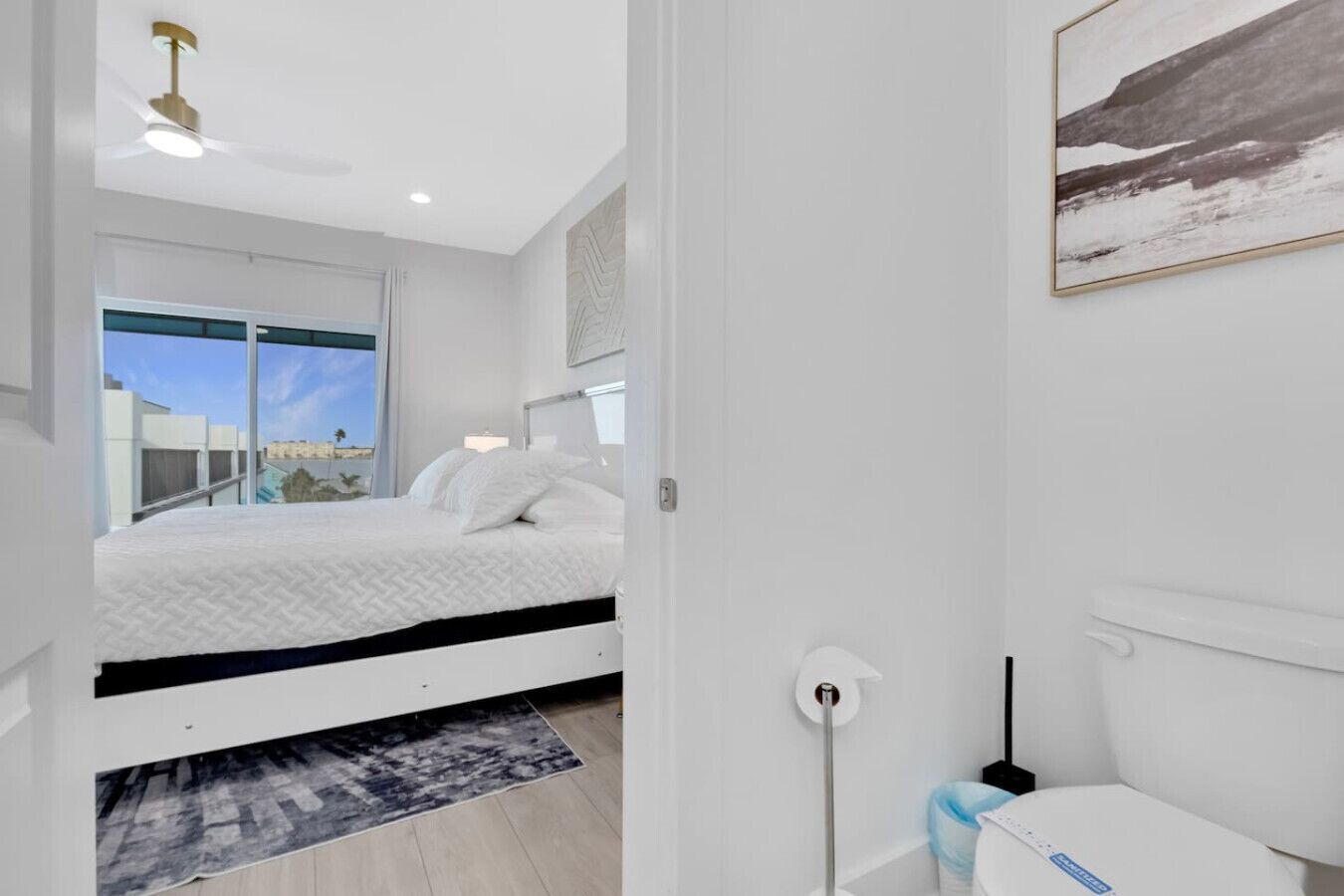 Ein modernes Schlafzimmer mit Bett, Fenster und Blick ins Freie.