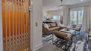 A modern living room with a sectional sofa, a coffee table, and a dining area.