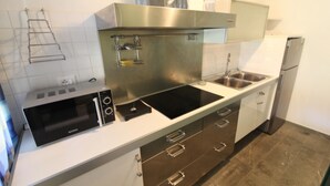 Una cocina moderna con microondas, estufa y lavaplatos integrados.