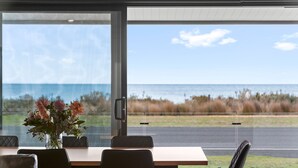 Un espace repas avec vue sur l’océan et la plage.