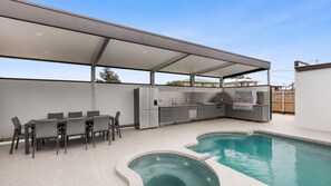 An outdoor kitchen with a pool, covered seating, and a barbecue area. - Portarlington Beach Retreat, A modern home across from the water (Portarlington)