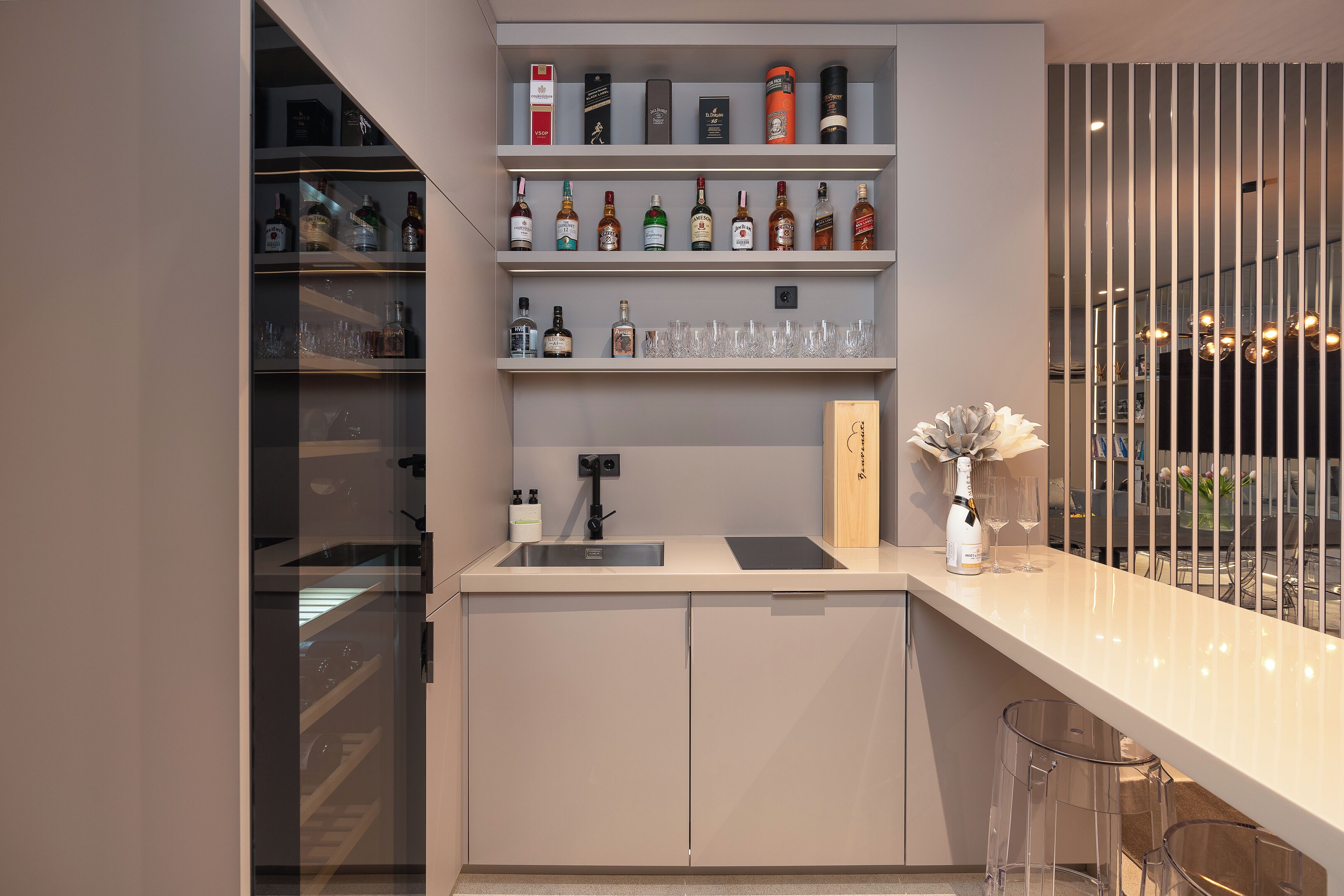 Una cocina moderna con una estantería para vinos, barra y vistas a la ciudad.
