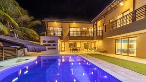 A two-story house with a swimming pool, outdoor seating, and a thatched roof structure. - Mansão Carneiros By Carpediem (Tamandaré)