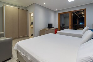 A hotel room with two beds, a desk with a computer, a wardrobe, and a balcony with a view. - Mansão Carneiros By Carpediem (Tamandaré)