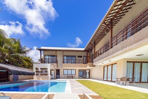 A two-story building with a swimming pool, outdoor seating, and a view of the sky. - Mansão Carneiros By Carpediem (Tamandaré)