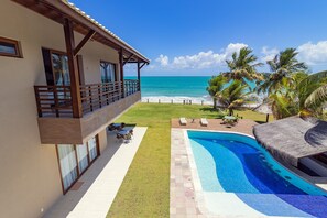 A resort with a swimming pool, a beach view, and a covered outdoor area with seating. - Mansão Carneiros By Carpediem (Tamandaré)
