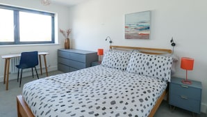 A bedroom with a bed, a desk, a chair, a dresser, a nightstand, and a window. - 6 Gwel Yr Wyddfa (Ty Croes)