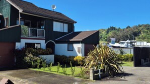 A two-story house with a satellite dish, a balcony, and a garage. - Esplanade Townhouse  (Gisborne)