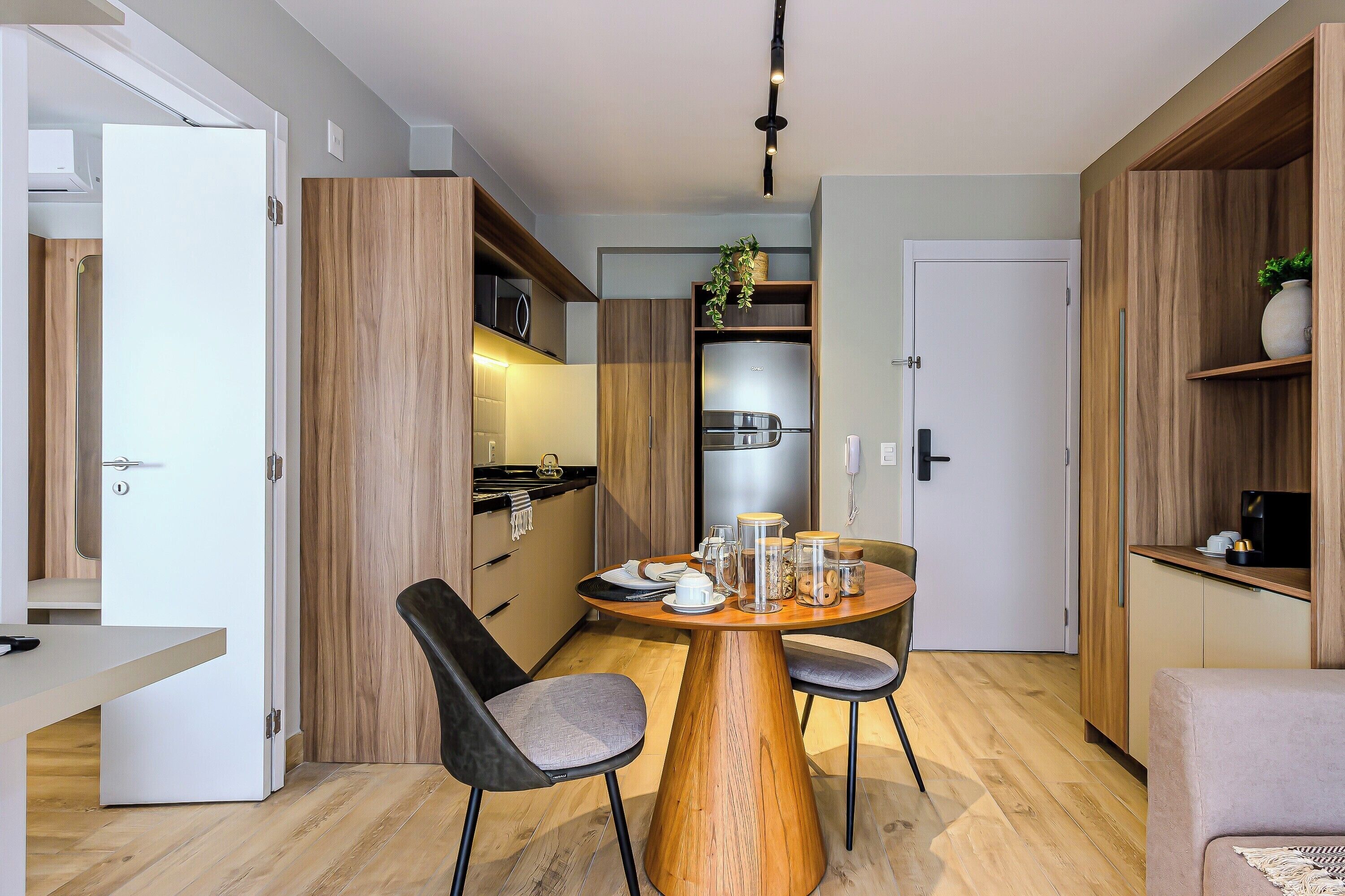 A compact kitchen with a central island, wooden cabinets, and a built-in refrigerator.