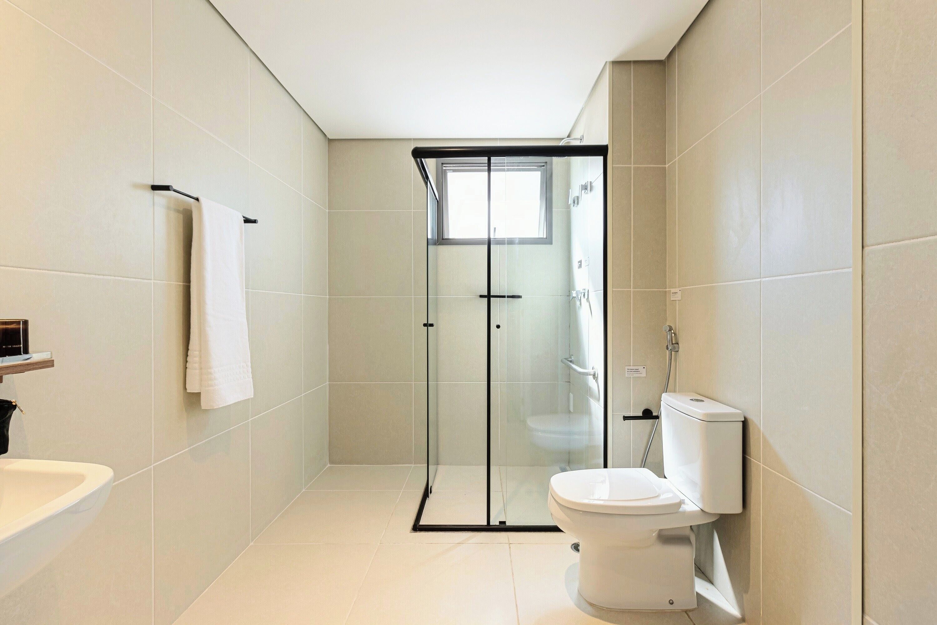 Ein modernes Badezimmer mit einer Glasdusche, einer weißen Toilette und einem Waschbecken.