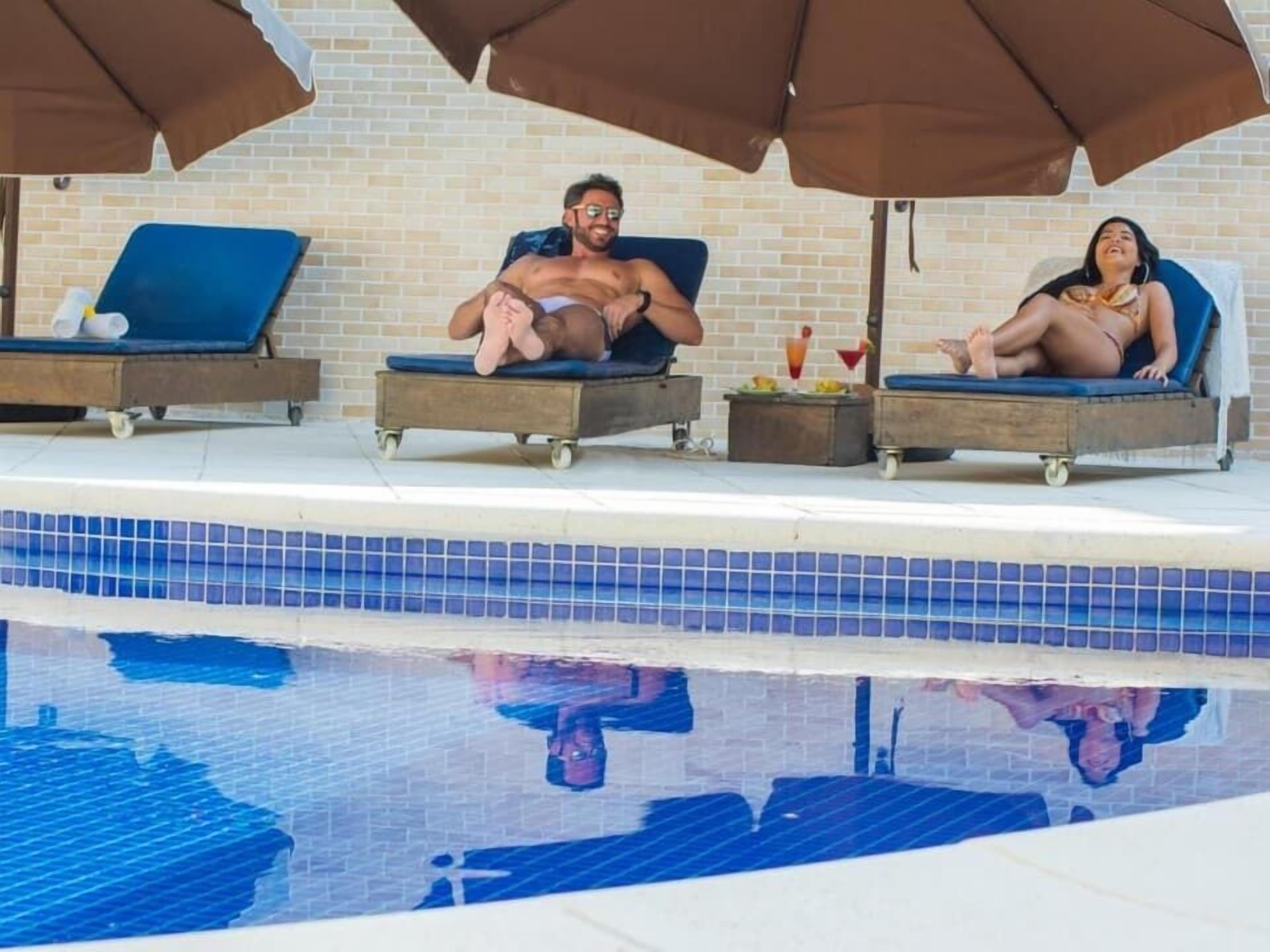 A poolside area with lounge chairs and umbrellas.