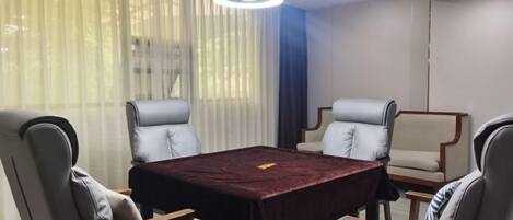 A conference room with a rectangular table, four chairs, and a modern chandelier.