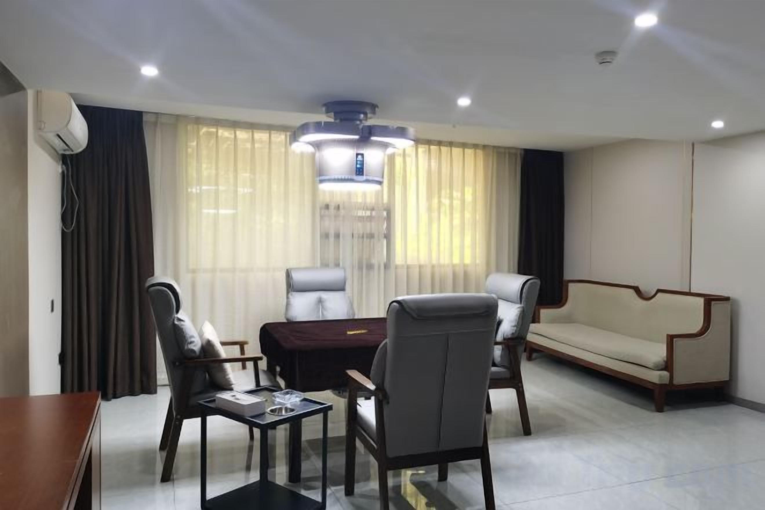 A modern living room with a sofa, two armchairs, a coffee table, and a dining table.