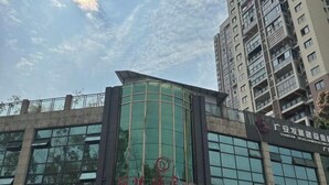 A modern building with a curved glass facade and a sign indicating it is a hotel. - Jialing Bandao Hotel (Wusheng)