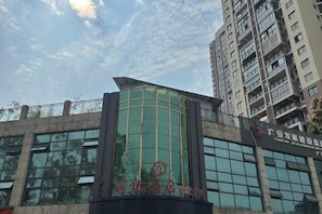 Un edificio moderno con fachada de vidrio curva y un letrero que indica que es un hotel.