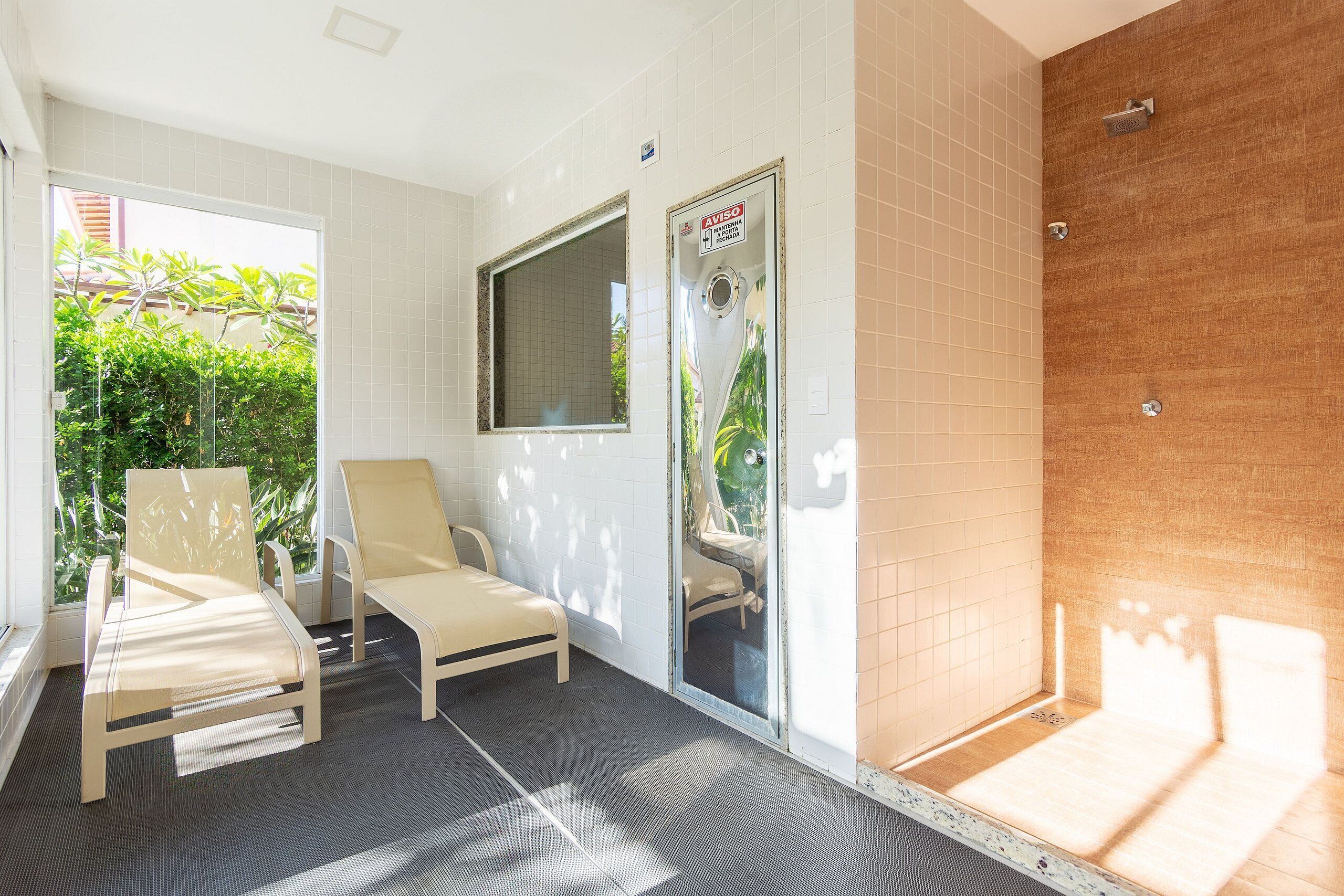 Ein Badezimmer mit Dusche, Sitzbank und Fenster.