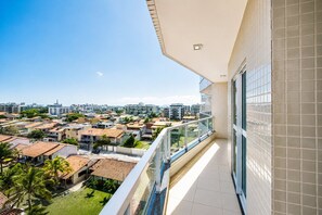 Un balcón con vistas a una zona residencial y un paisaje urbano.