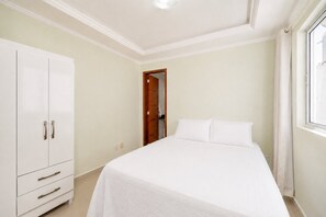 Un dormitorio con cama, armario y puerta que da a otra habitación.
