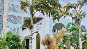 Un edificio moderno con fachada blanca, ventanas de celosía decorativas y un elemento circular central.