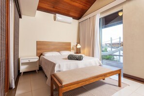 A bedroom with a bed, bedside table, bench, and a view of a bridge. - 40m from the beach! Beautiful house with private pool BZ26 (Armação dos Búzios)