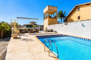 A swimming pool with a clear blue water, surrounded by lounge chairs and a white wall. - House 300m from Geribá beach with gourmet area BZ08 (Armação dos Búzios)