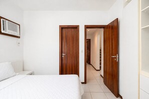 Ein Schlafzimmer mit einem Bett, einem Kleiderschrank und einem Flur, der zu einem weiteren Raum führt.