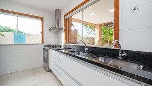 A modern kitchen with a large window, stainless steel sink, and white cabinetry. - Bz38 House 150m from the beach with private pool (Armação dos Búzios)