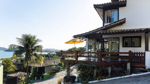 A modern house with a balcony, a palm tree, and a view of the sea. - Bz20 Geribá with panoramic views! 6 bedrooms (Armação dos Búzios)
