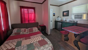 A compact room with a bed, a small kitchenette, and a dining table. - Squaw Valley Motel Room #1 (Yokuts Valley)