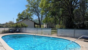 A rectangular swimming pool with a white deck and a metal ladder. - Squaw Valley Motel Room #1 (Yokuts Valley)