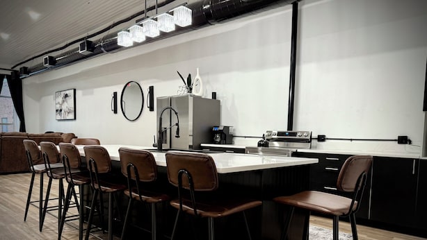 A modern kitchen with a central island, bar stools, a refrigerator, and a coffee machine. - “Downtown Boro Loft” Charming 1600 sq foot open concept Downtown Jacksboro (Jacksboro)