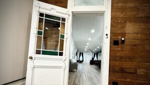 A hallway with a white door leading to a room with a wooden floor and a ceiling fan. - “Downtown Boro Loft” Charming 1600 sq foot open concept Downtown Jacksboro (Jacksboro)
