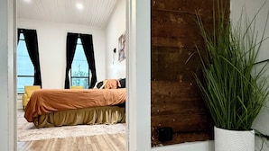 A bedroom with a bed, a ceiling fan, a large window, and a potted plant. - “Downtown Boro Loft” Charming 1600 sq foot open concept Downtown Jacksboro (Jacksboro)