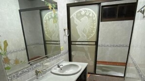 Un baño moderno con lavamanos, espejo y retrete.
