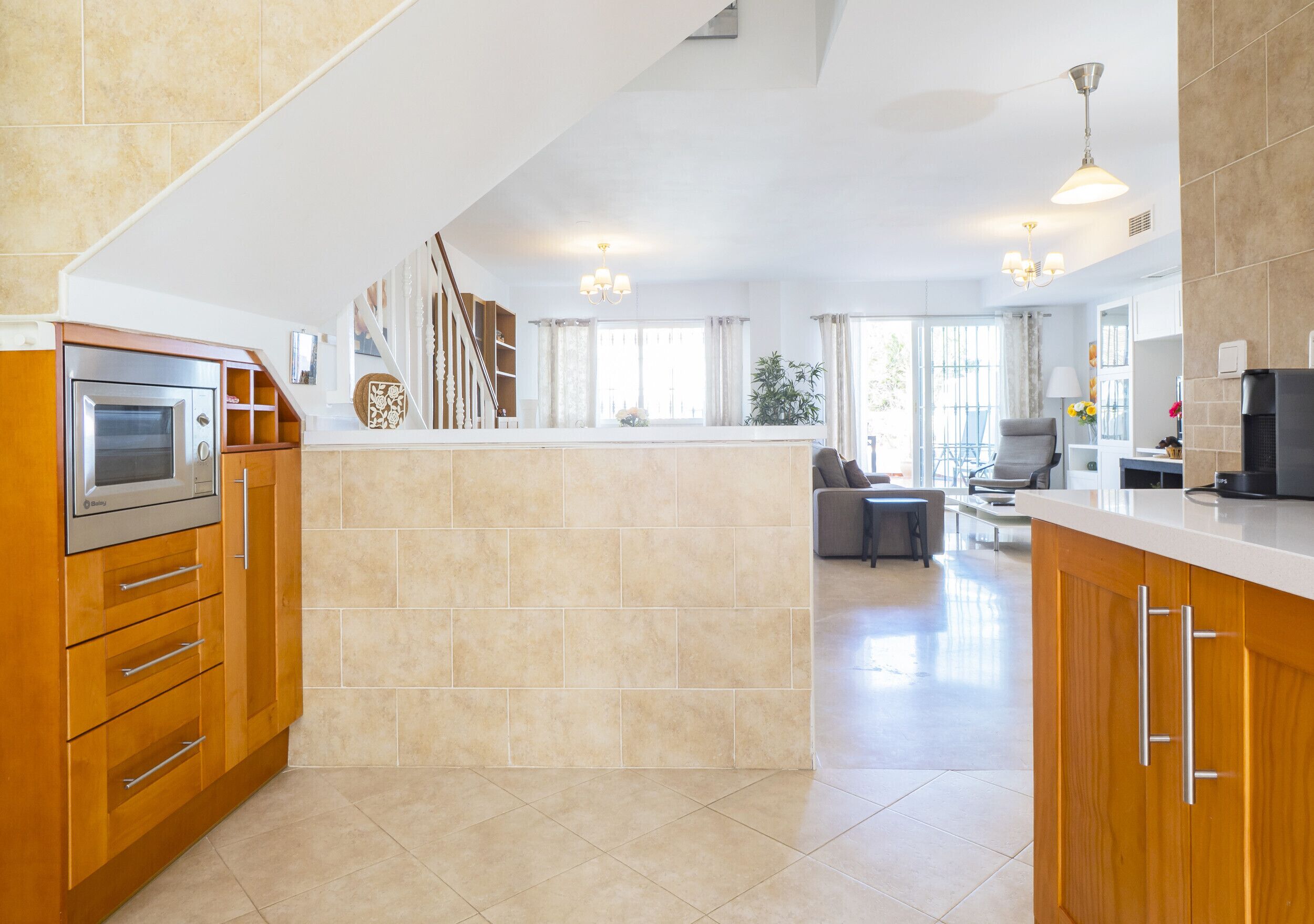 Een moderne keuken met een centraal eiland, houten kasten en roestvrijstalen apparatuur.