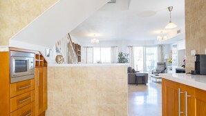 Una cocina moderna con una isla central, armarios de madera y electrodomésticos de acero inoxidable.