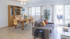 Una sala de estar moderna con comedor, un sofá, una mesa de centro y una estantería.