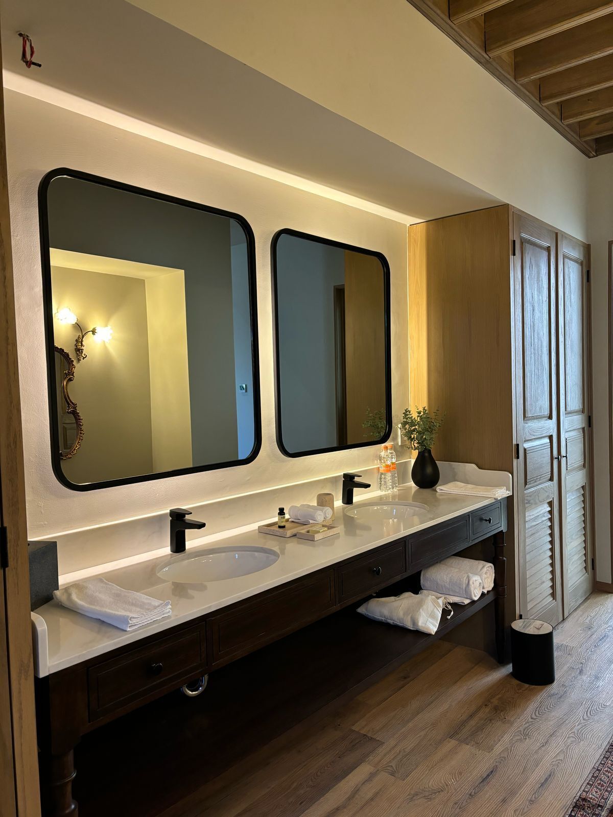 Une salle de bain moderne dotée d’un meuble-lavabo double, de deux vasques et d’un grand miroir.