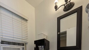 A bathroom with a toilet, sink, and mirror. - Squaw Valley Motel Room #2 (Yokuts Valley)