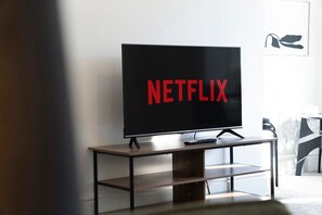 A television on a wooden stand with a black frame, displaying the Netflix logo. - Spacious Retreat at Durham Road (County Durham)