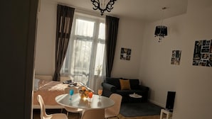 A compact living space with a dining area, a sofa, and a bed.