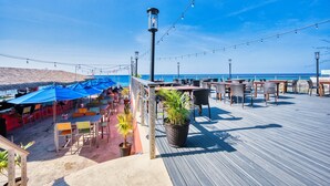 A wooden deck with outdoor seating and a view of the ocean. - Sunset Point: Chic Meets Luxury, Sophisticated Style Meets Ocean Serenity (West Bay)
