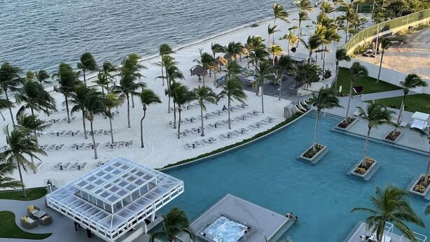 Un resort con piscina, playa y vista al océano.