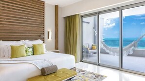 Un hotel moderno con una cama grande, vista al océano y una hamaca en el balcón.