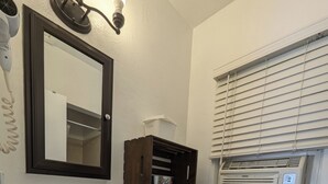A bathroom with a white sink, dark wooden vanity, a toilet, and a window with blinds. - Squaw Valley Motel Room #3 (Yokuts Valley)