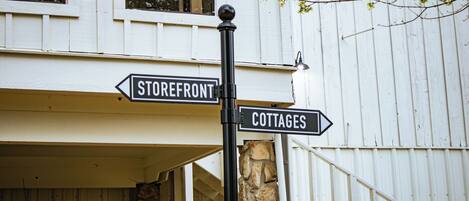 Una señal de calle indica el camino hacia 'Storefront' y 'Cottages'.