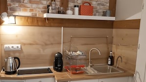 Eine kleine Küche mit Holzarbeitsplatte, Spüle und Kaffeemaschine.