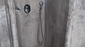 A small, tiled shower area with a handheld showerhead and a wall-mounted faucet. - Studio in Perissa beach for 4 people (thira)