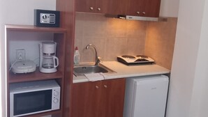 A compact kitchen with a microwave, coffee maker, and a small refrigerator. - Studio in Perissa beach for 4 people (thira)